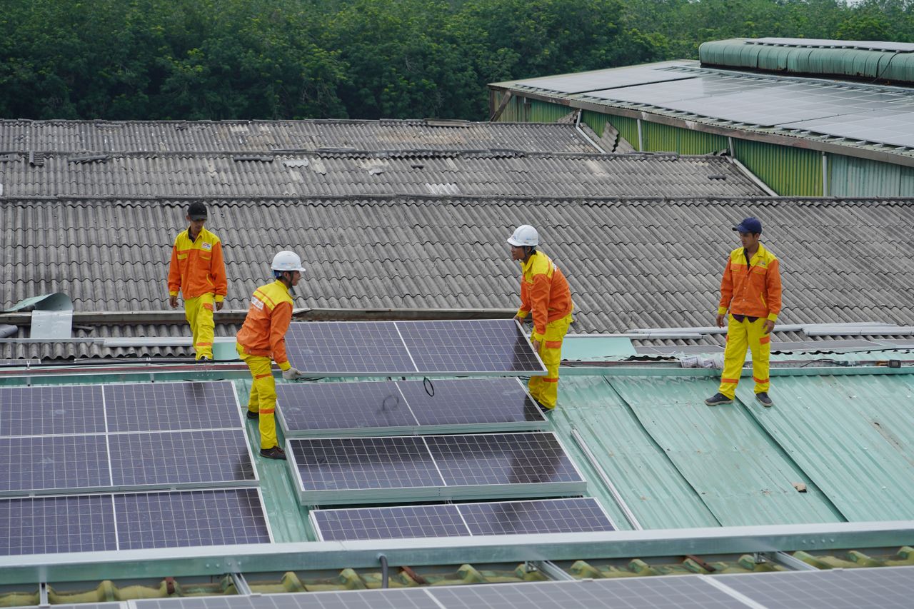 Home Workers installing solar panels on a roof for sustainable energy solutions.