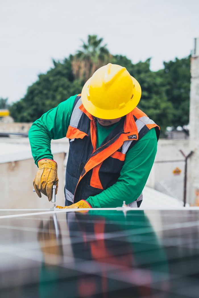 Services Professional solar panel technician working outdoors with PPE.