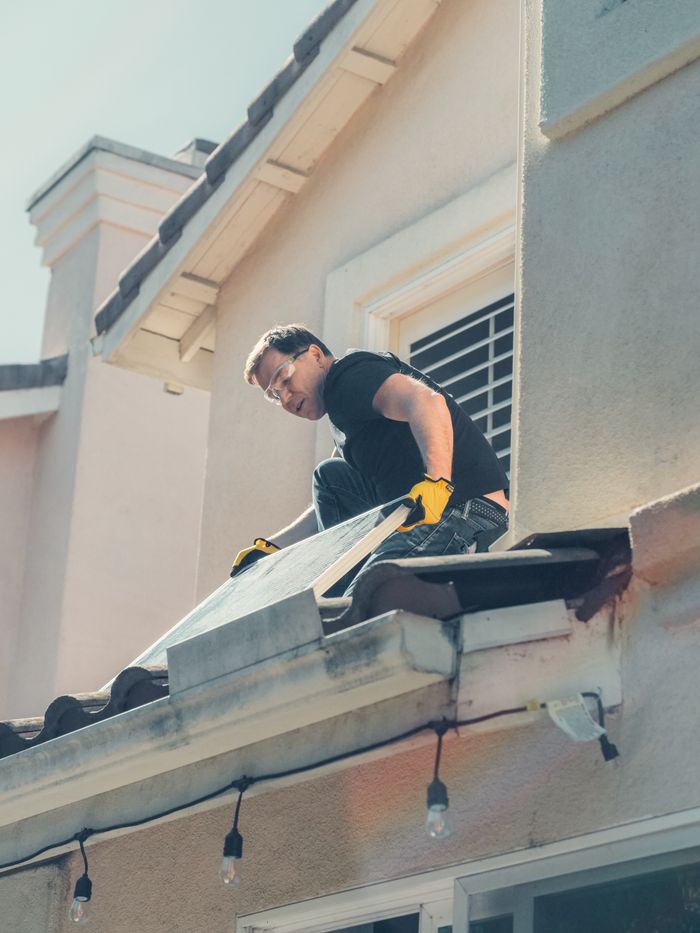 Crafting Captivating Headlines: Your awesome post title goes here A worker is installing solar panels on a residential rooftop, promoting clean energy.